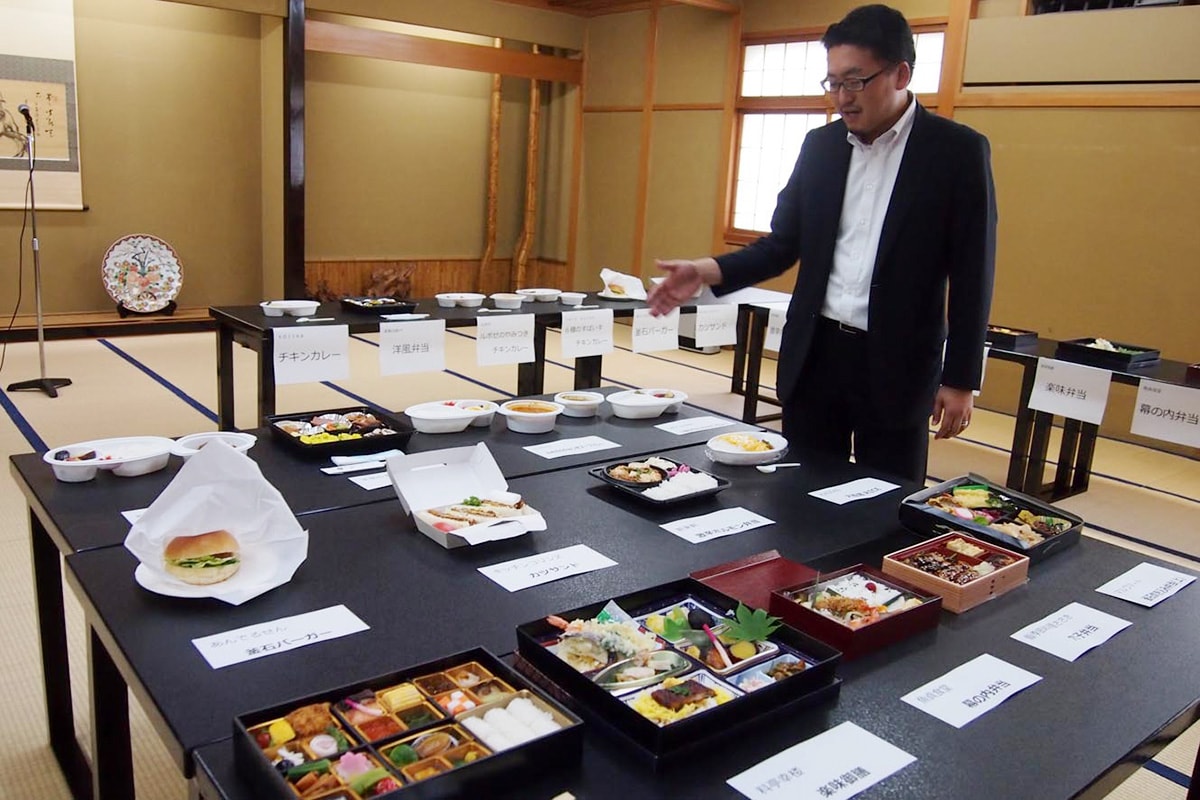 釜石と大船渡の人気の味を詰め込んだ13種類の「シェフズ弁当」を説明する小澤社長
