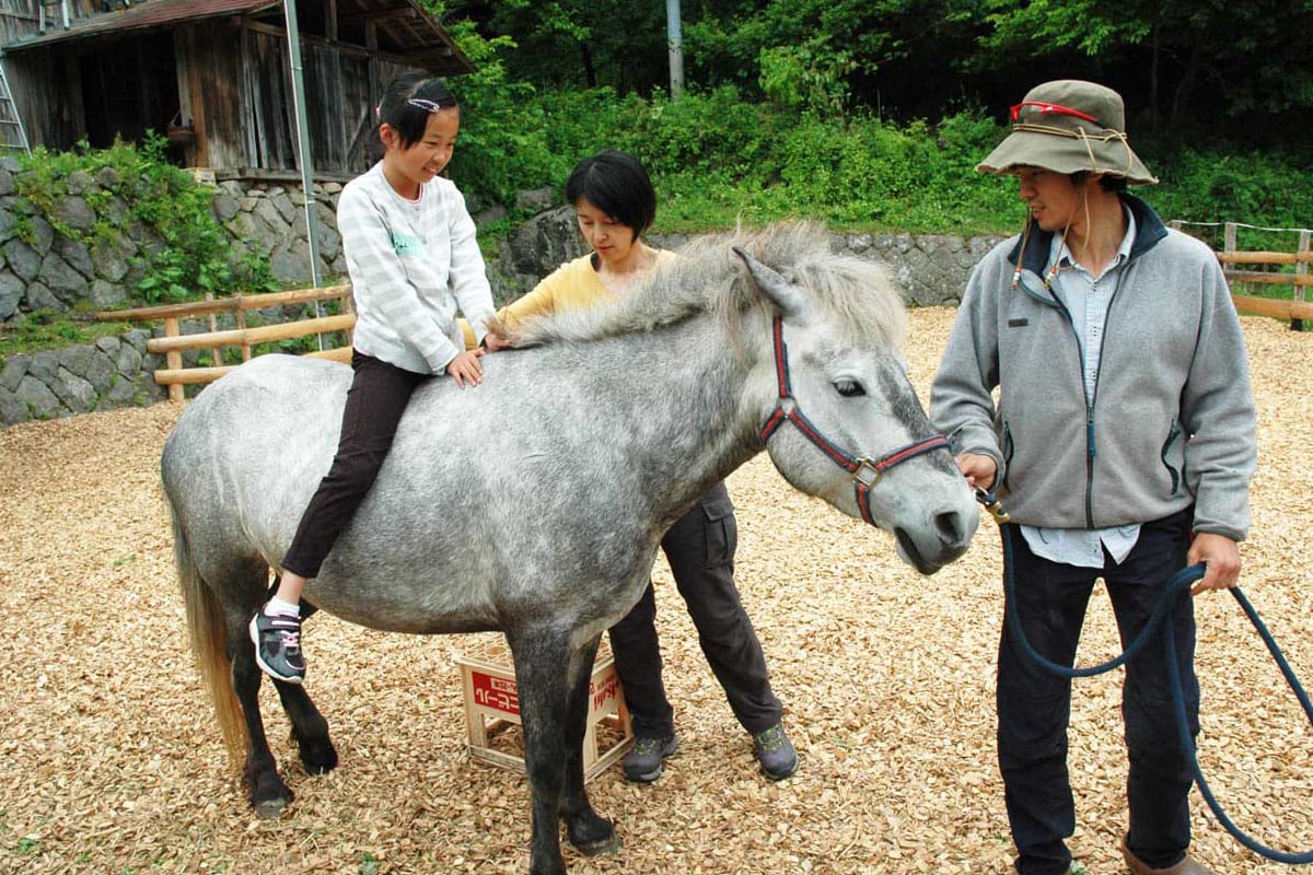 黍原豊さん（右）が引く馬に乗り、何ともいえない心地良い感覚に身をゆだねた乗馬体験