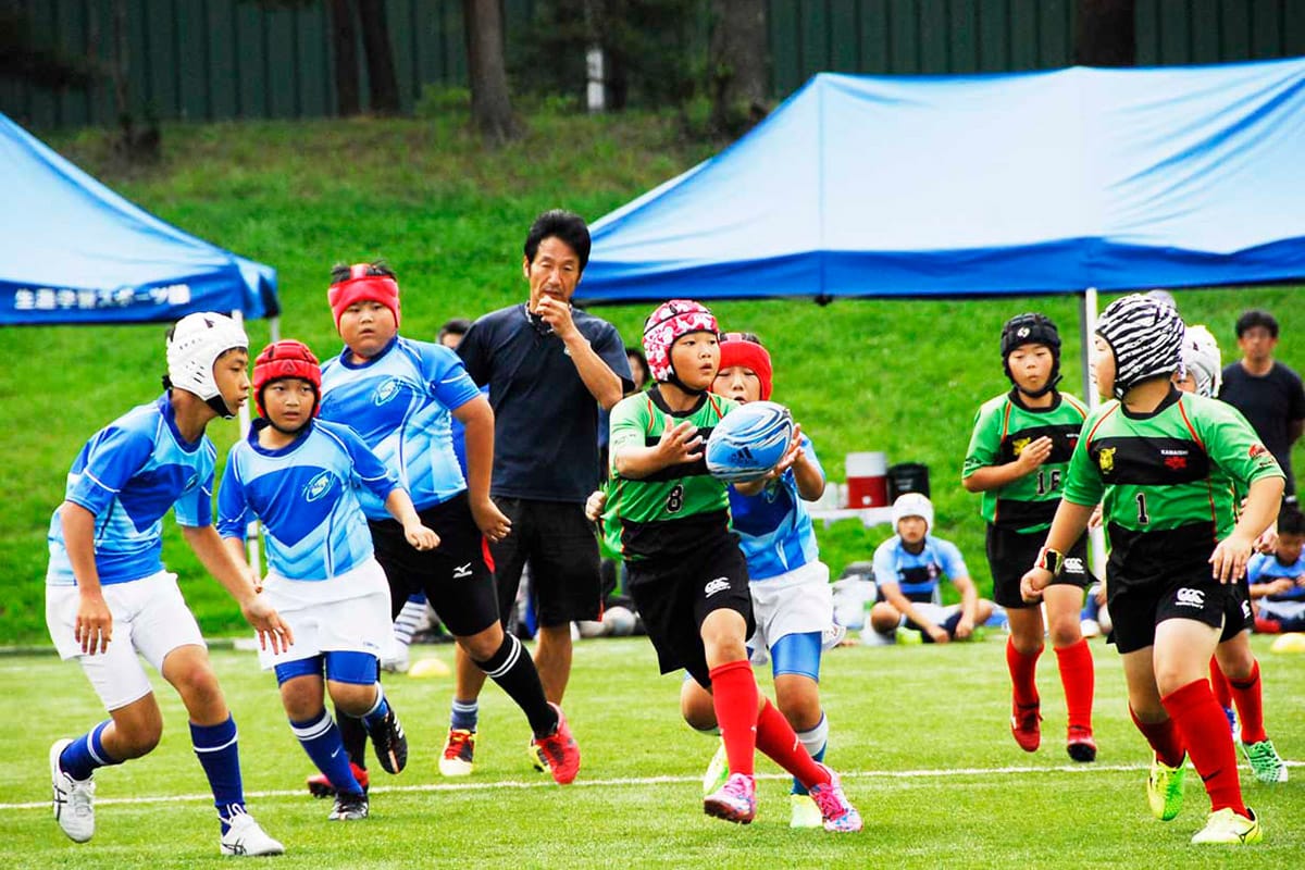 ミニゲームで交流する東大阪ラグビースクール（青）と釜石シーウェイブスジュニア（緑）の子どもたち