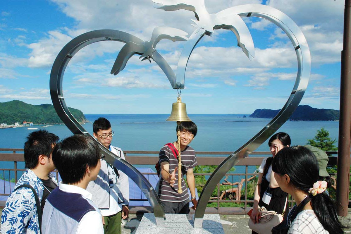 釜石湾の絶景に映える「恋人の聖地」モニュメントを見学するツアー参加者