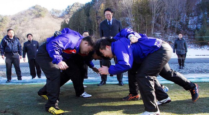 スクラムを組み、釜石鵜住居復興スタジアムに敷く芝生の感触を確かめる釜石ＳＷの選手ら
