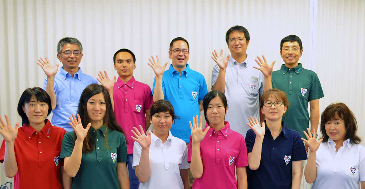 「かまリン」をあしらったポロシャツを着用する発案者の藏本英司さん（後列中）、釜石市職員ら
