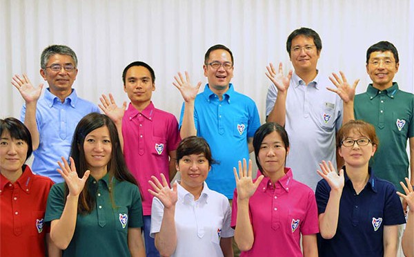 「かまリン」をあしらったポロシャツを着用する発案者の藏本英司さん（後列中）、釜石市職員ら