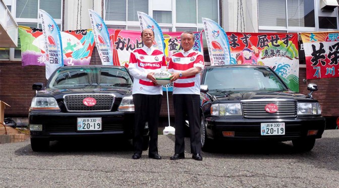 特別仕様のナンバープレートを取り付けた公用車を前に野田市長（右）と佐々木議長