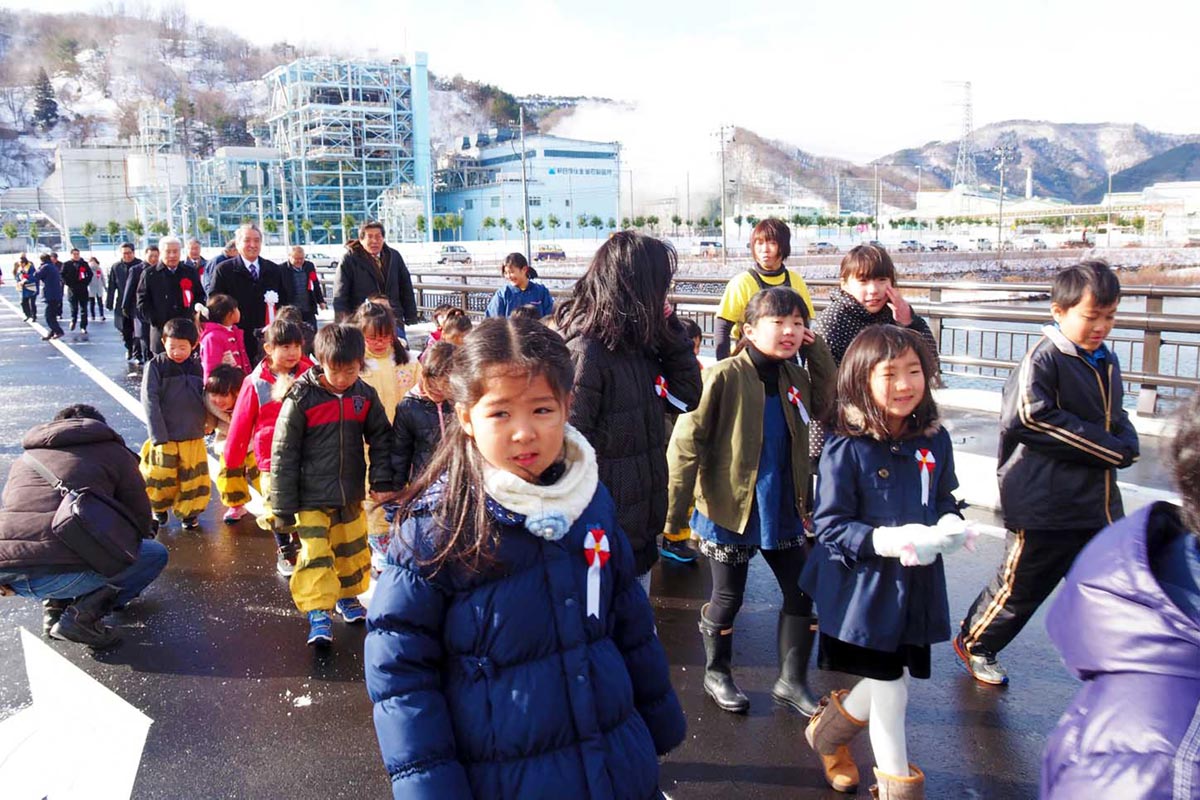 中心市街地のにぎわいや釜石港の物流機能強化につながると期待される千年橋を渡り初めする子どもたち