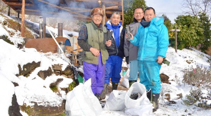 雪景色の中で技術を高める「炭焼き人」（左端・小澤さん、右端・山口さん）