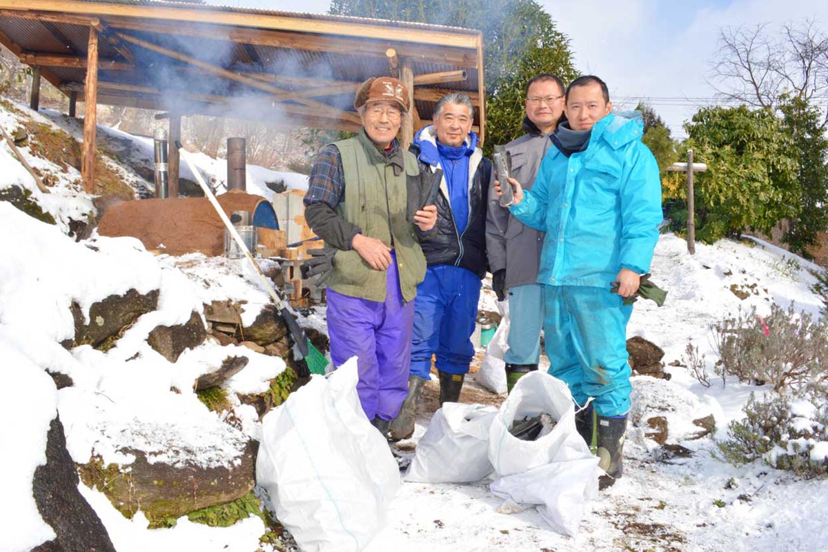 雪景色の中で技術を高める「炭焼き人」（左端・小澤さん、右端・山口さん）