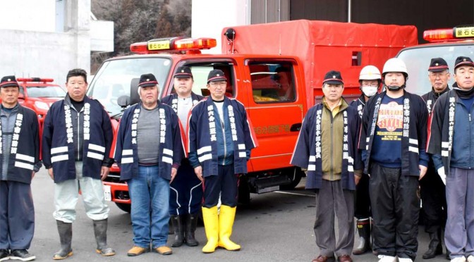 新しいポンプ、積載車の配備を喜ぶ消防団第６分団第７部（左）、第８分団第６部の団員ら