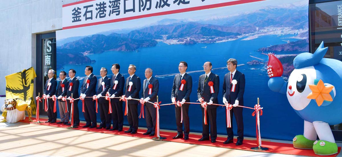 国家的プロジェクト釜石港湾口防の復旧を喜びテープカットする関係者