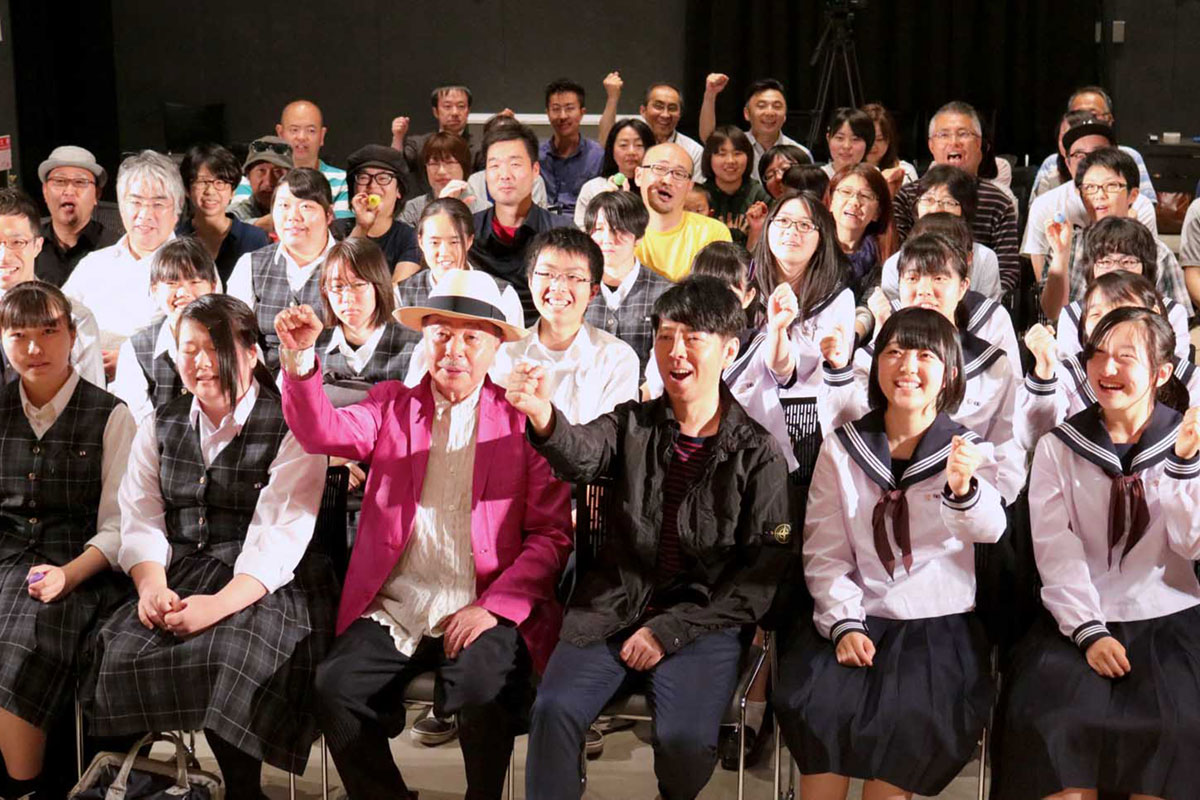 浅葉克己さん（前列中央左）と佐藤可士和さん（同右）を囲んで記念撮影する市民ら