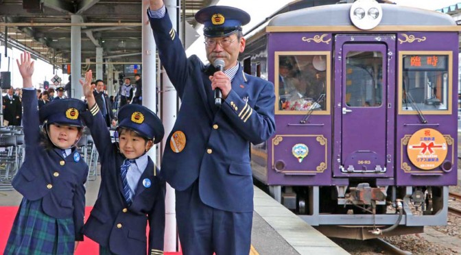 釜石駅長とともに「出発進行」と手を上げる双子の園児
