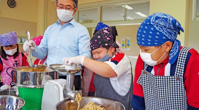 小山さん（右から３人目）のサポートを受けながらみそづくりに取り組む釜石小児童