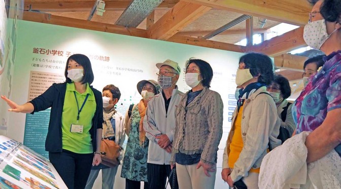 いのちをつなぐ未来館を見学する平田いきいきサークルの会員。川崎さん（左）の説明に耳を傾けた