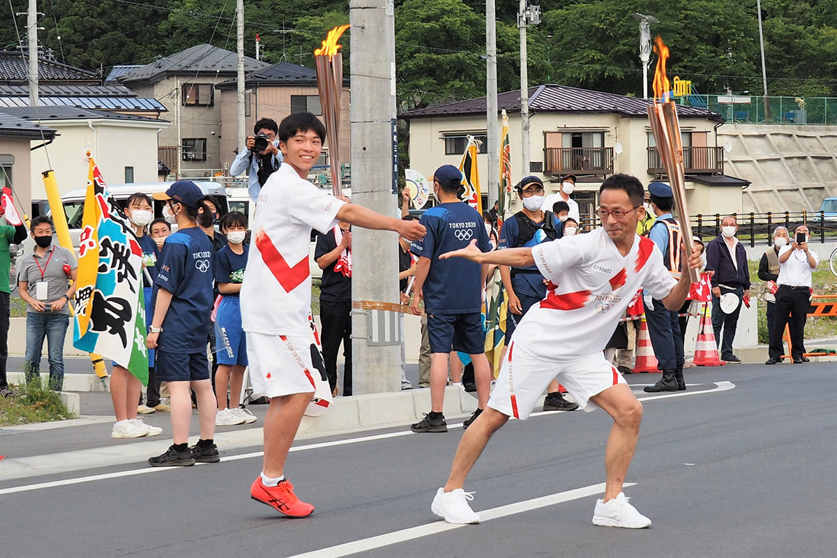 「バトンタッチ」。トーチキスでポーズを決める奥村晄矢君（左）と横田信之さん
