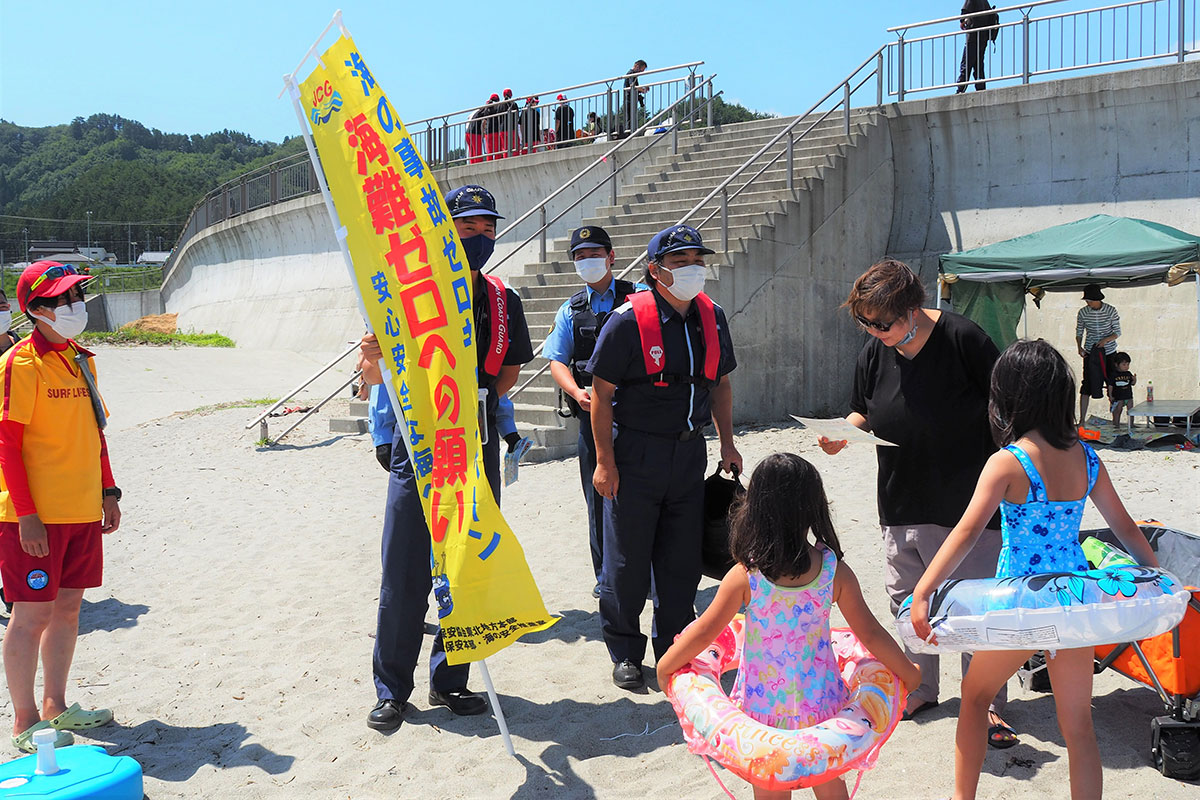 釜石海上保安部職員らが海水浴客に声掛けを行った＝２５日