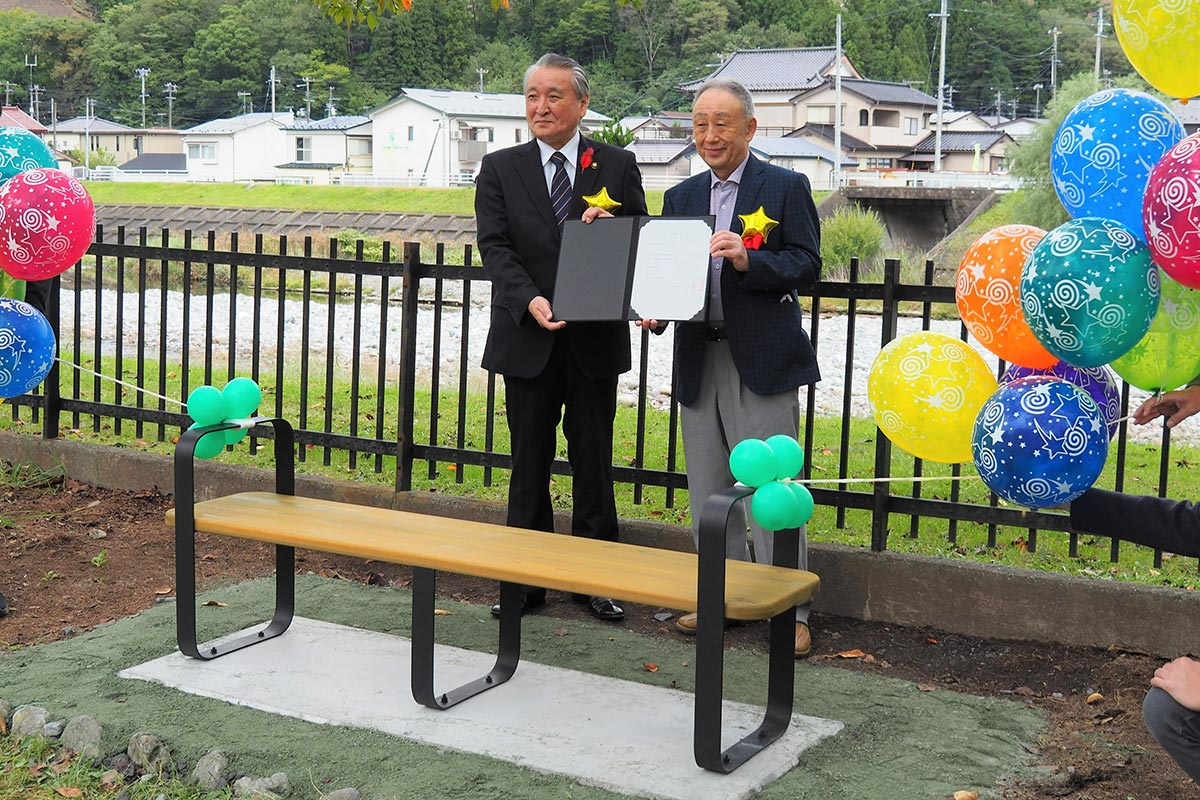 寄贈書を手にする小泉会長（右）と野田市長