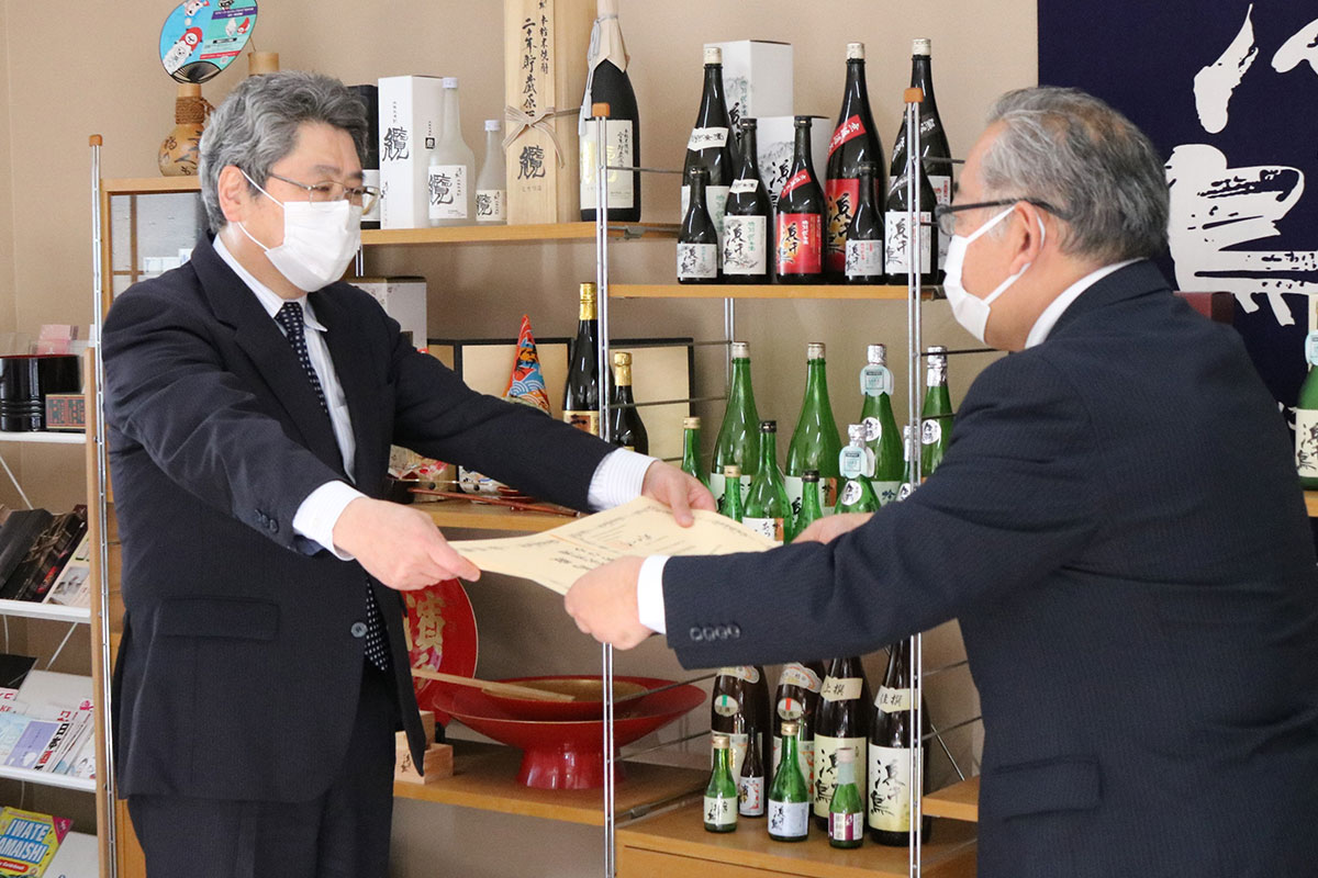 釜石税務署の霜崎良人署長から表彰状を受け取る浜千鳥の新里進社長（左）