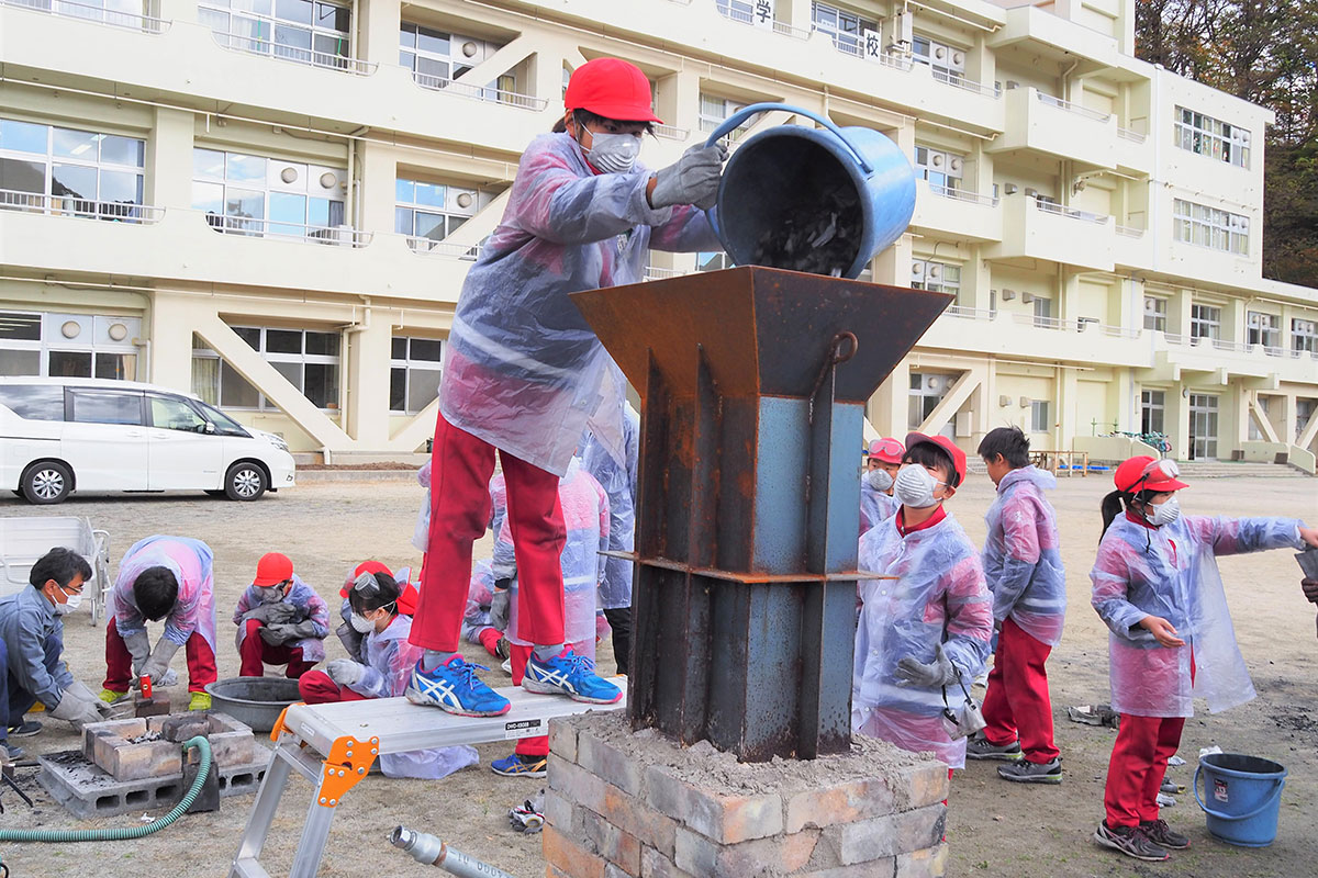 釜石小5年生が挑んだ鉄づくり。れんがで積んだ炉に炭を入れる＝12日