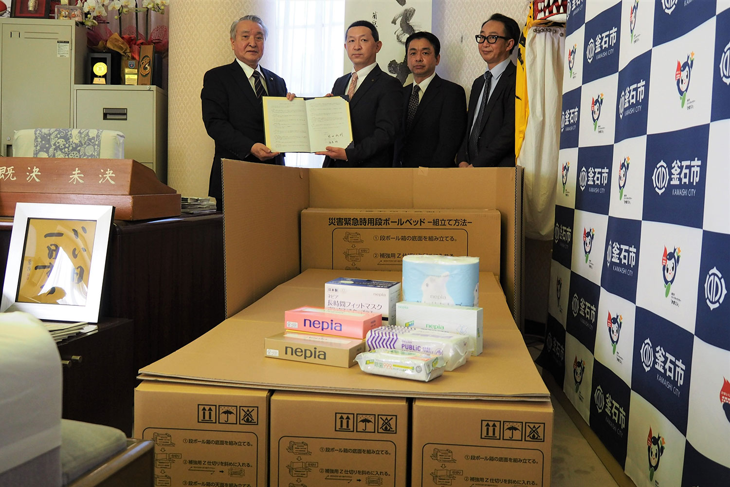 協定書を手にする野田市長（左）と福島工場長（左から２人目）ら。災害時に段ボールベッドなどの提供を受ける