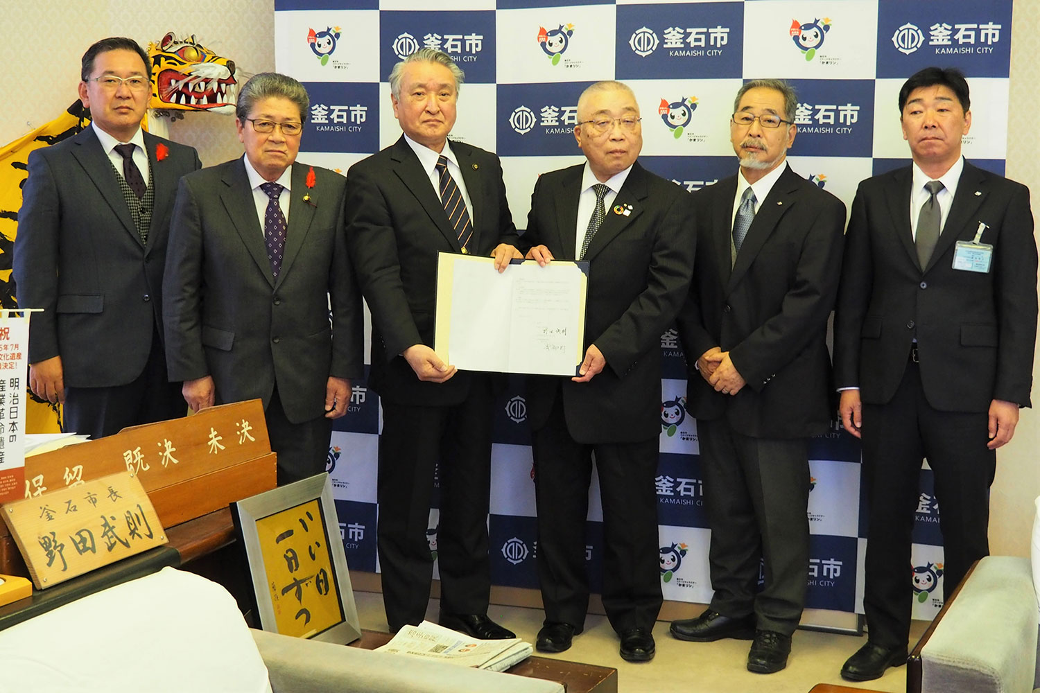 協定書を手にする野田市長（左から３人目）と青柳理事長（同４人目）