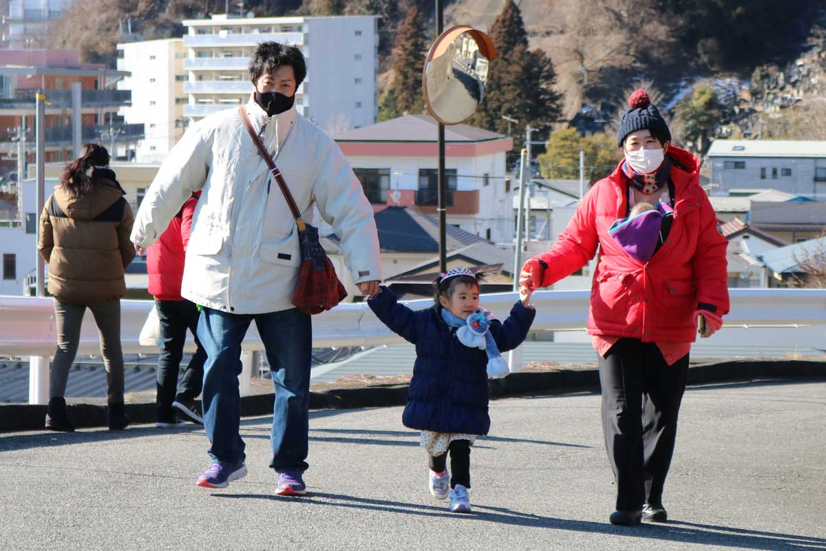 津波時の避難経路を確認しながら急坂を上る家族