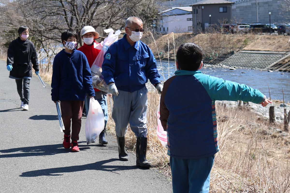甲子川沿いを歩き、ごみを拾う参加者。通行者のマナーアップを願う 