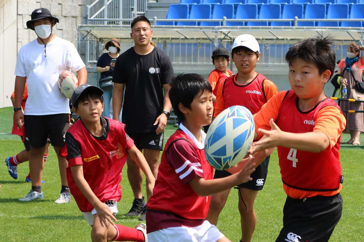 茂野海人選手（黒Ｔシャツ）が見守る中、パス練習に励む小学生
