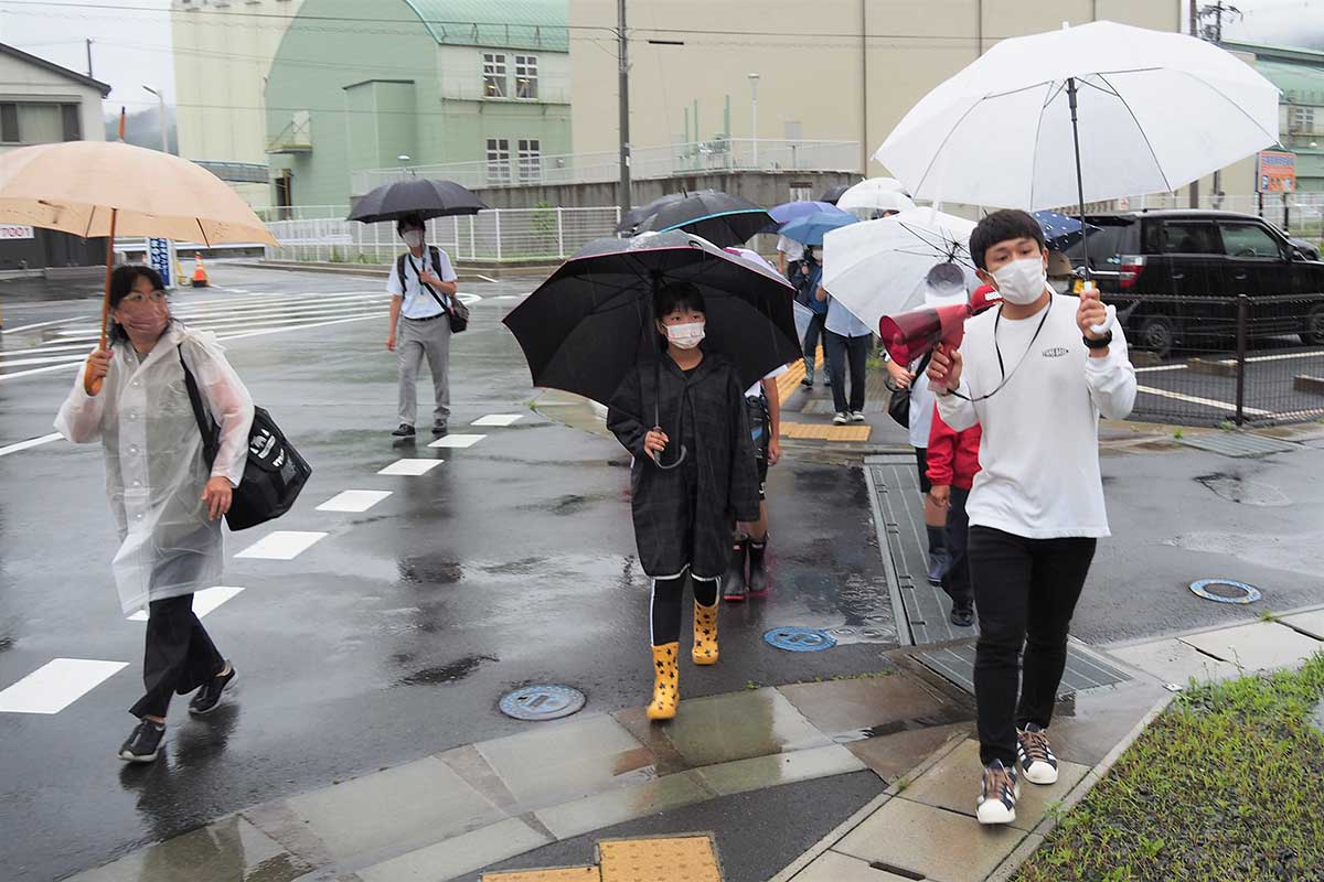 篠原優斗さん（手前右）と避難先ルートを歩く児童たち