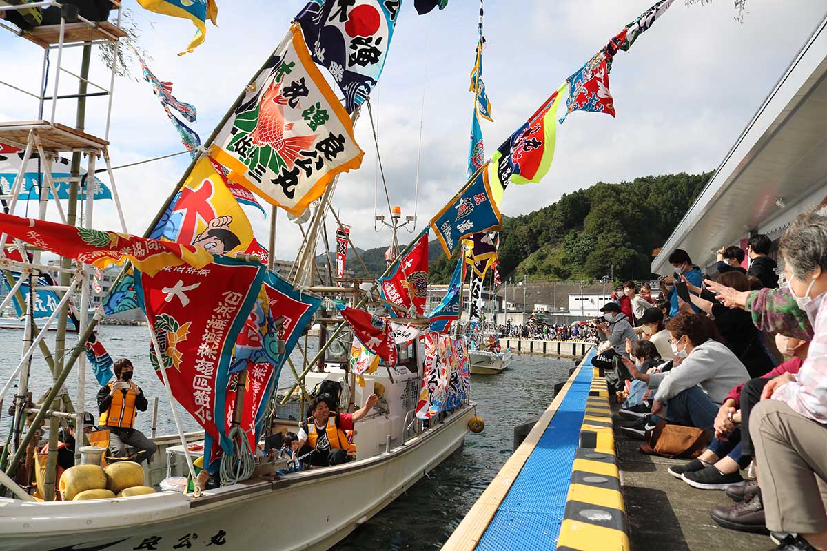 色とりどりの大漁旗をなびかせ進む漁船＝釜石市魚市場前