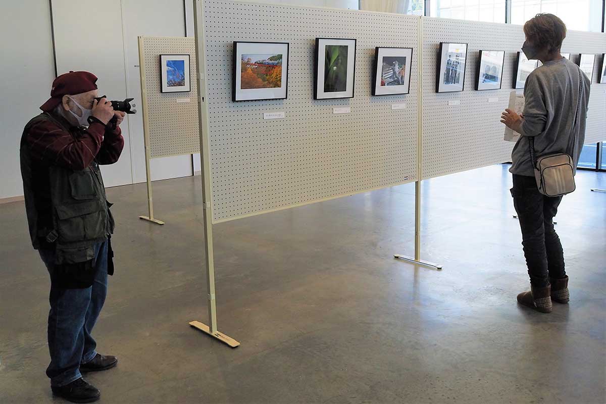 展示会場でもカメラを手に「日常」を写す多田代表（左）＝20日・TETTO