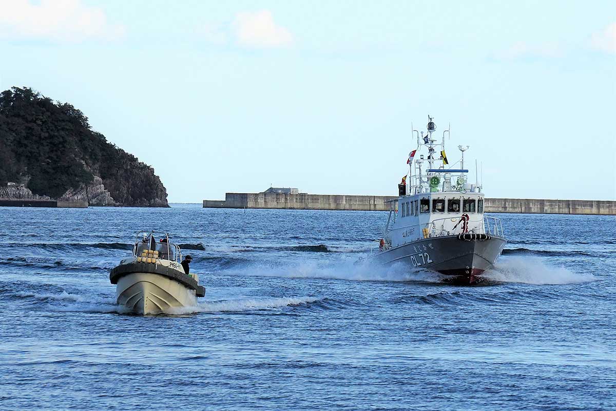 洋上で逃げるテロリストの小型ボート（手前）を追跡する釜石海上保安部の巡視艇