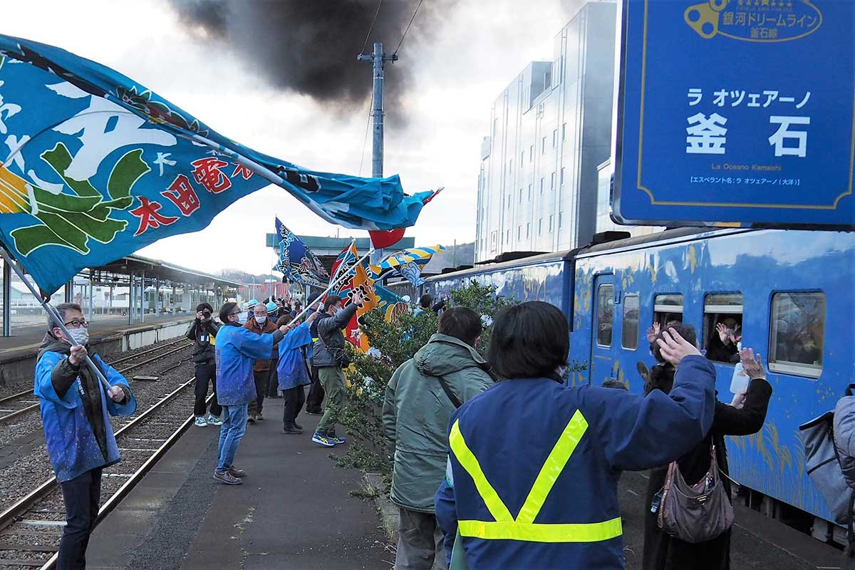 大漁旗を振って花巻行きの列車を見送る釜石市民ら