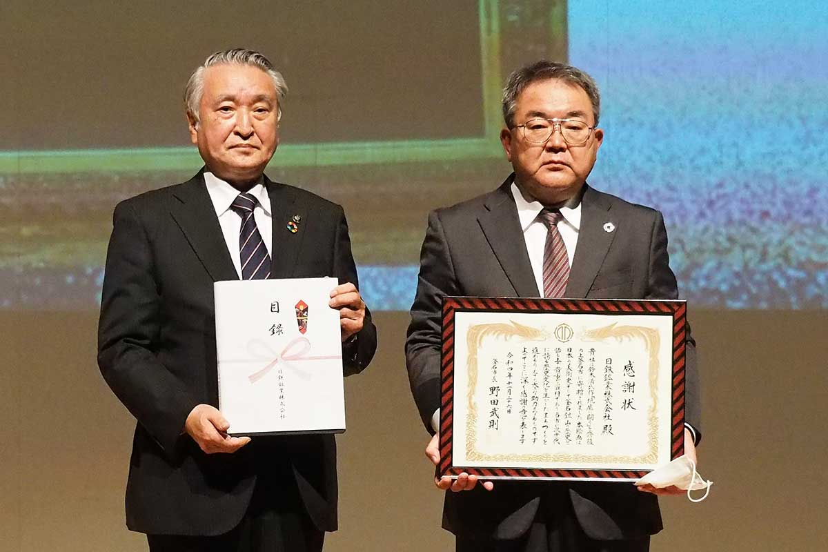 絵画の寄贈式に臨んだ渕上範敏社長（右）、野田武則市長