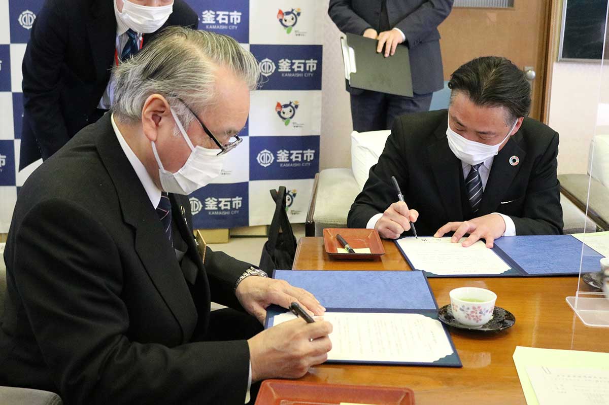 野田市長（左）と谷代表取締役が協定書に署名