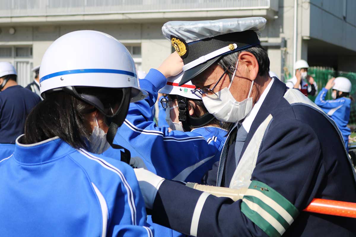 市交通指導隊員からヘルメットの正しい着用の仕方を学ぶ