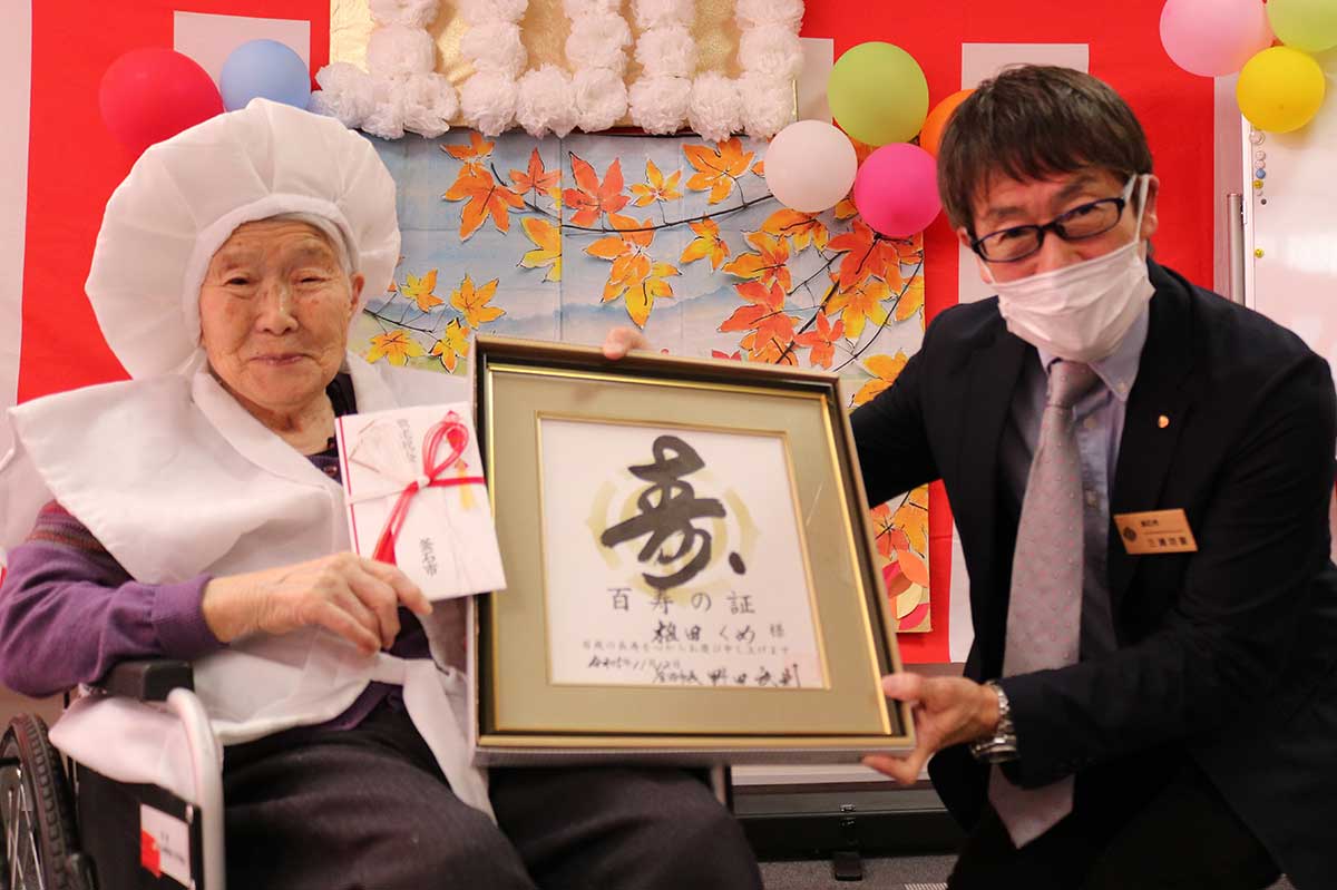 釜石市から100歳のお祝い金や祝い状を贈られた植田くめさん（左）