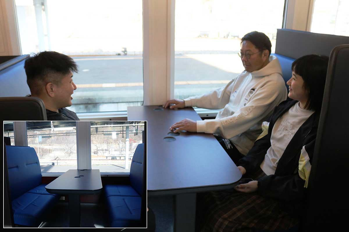 グリーン車の4人掛けシートの感触を確かめる日本製鉄釜石SWの桜庭吉彦GM（右奥）ら。見学者に翌日のホーム開幕戦をPRした