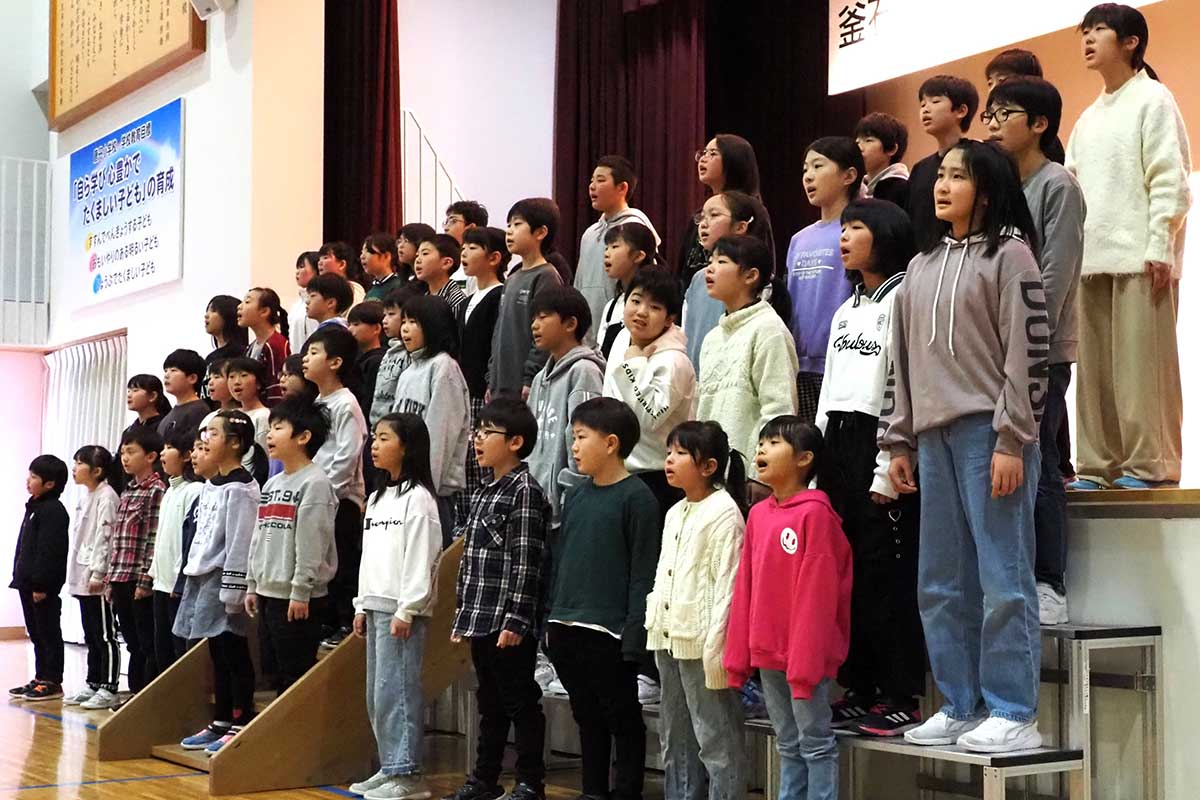創立150周年記念式典で元気な歌声を響かせる唐丹小児童