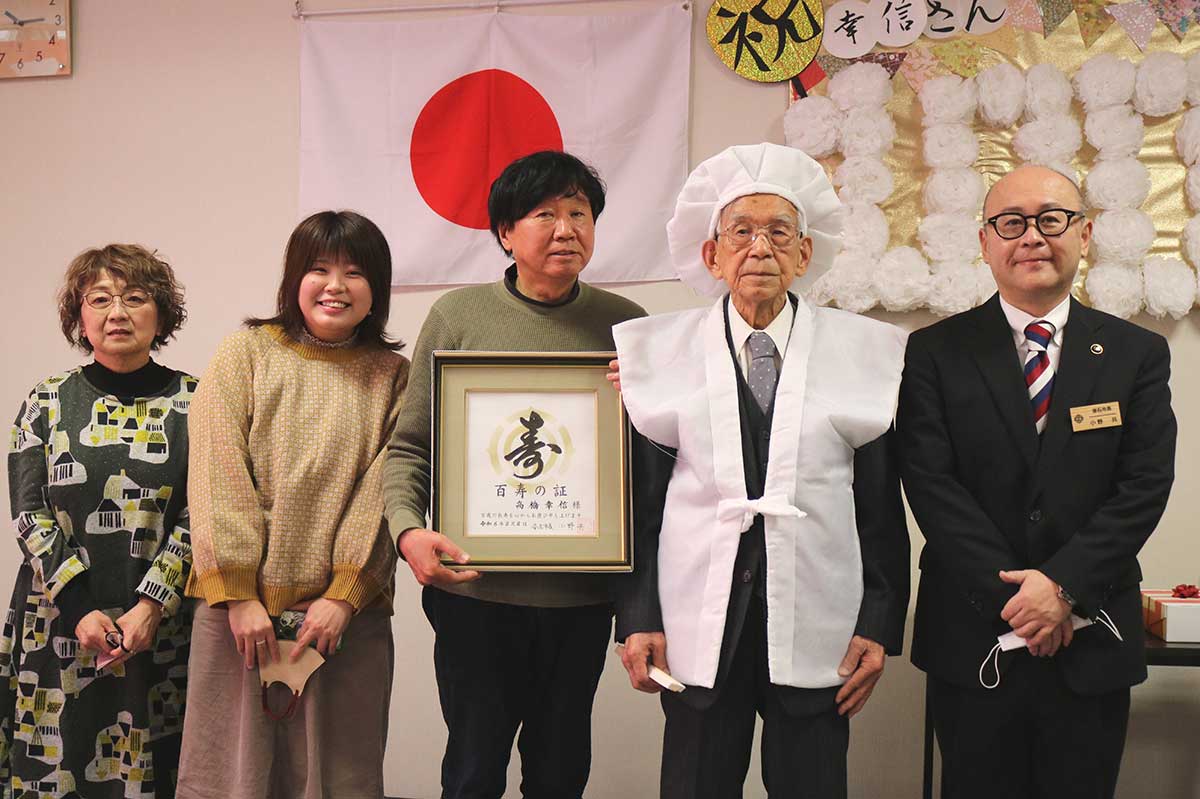 100歳を迎えた高橋幸信さん（右から2人目）。小野共市長（右）、長男邦友さん家族（左側）がお祝いに駆け付けた