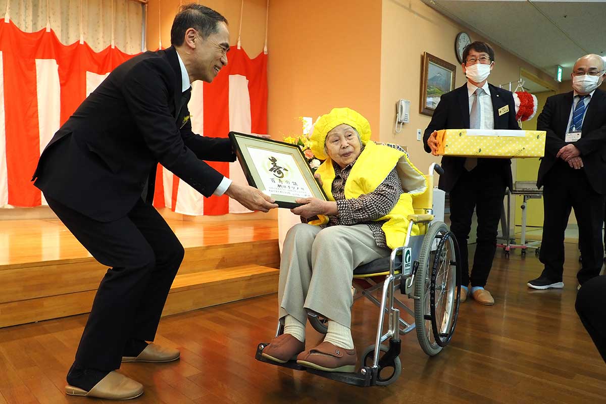 栁田さんに記念品を贈る平松福寿副市長（左）ら