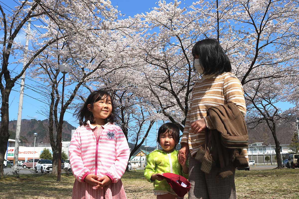 満開の桜の下で花見を楽しむ親子＝13日、上中島町