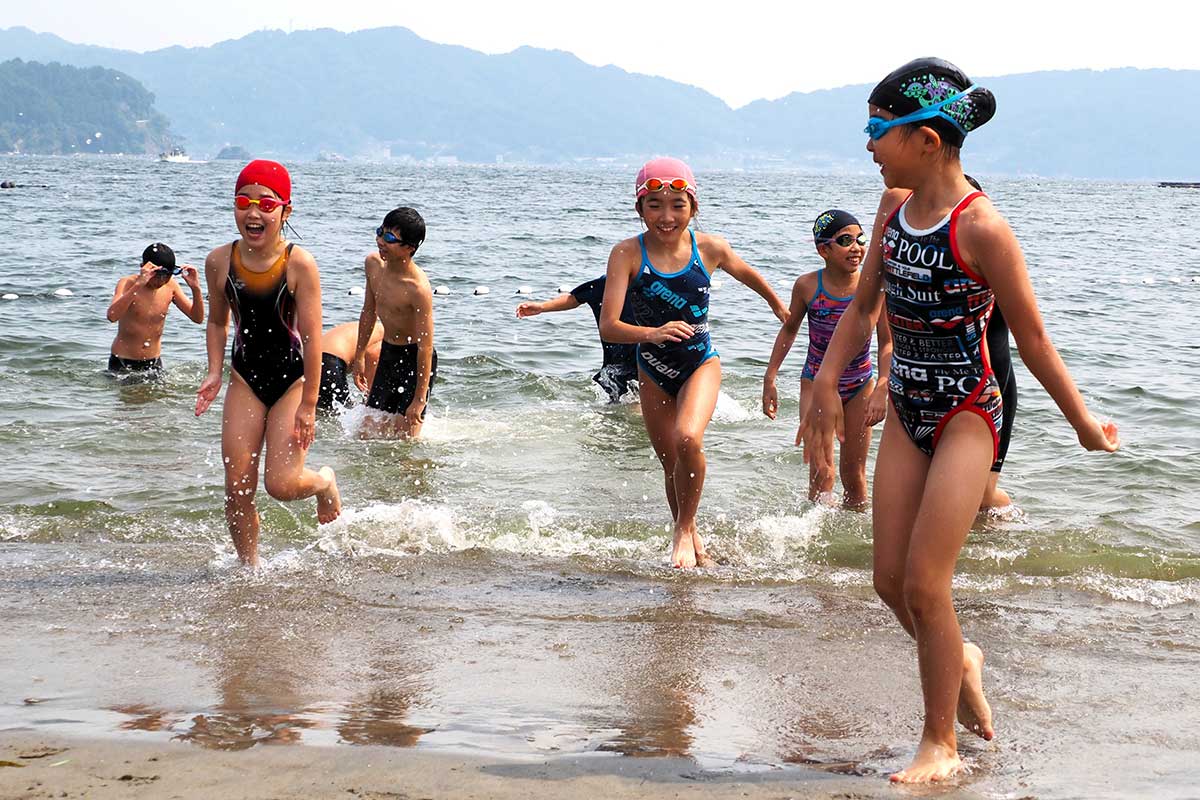 海開きした根浜海岸海水浴場で初泳ぎを楽しむ子どもたち＝7月13日