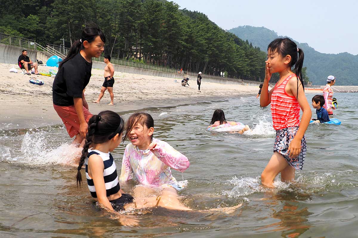 波打ち際も遊び場。水しぶきと歓声を上げる子どもたち