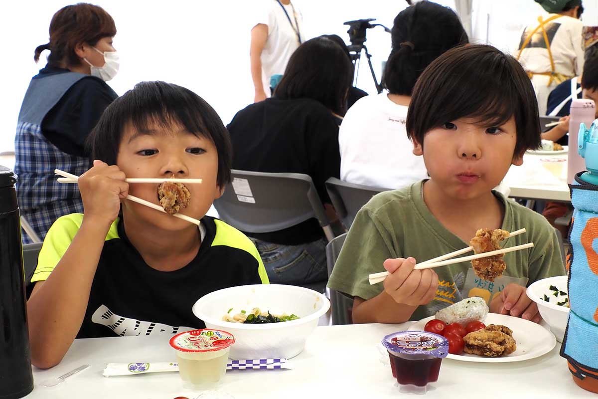 口を大きく開けてパクリ。唐揚げを頬張る子ども