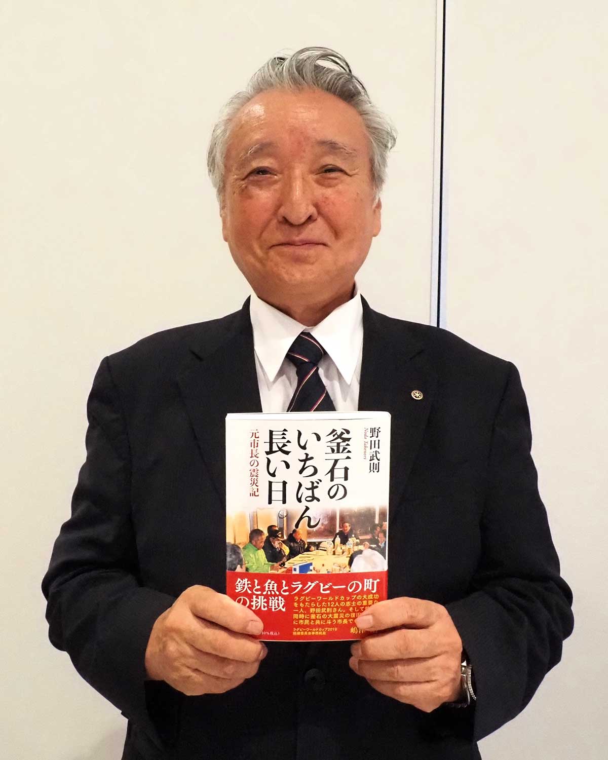 震災復興を振り返る著書を手にする野田さん