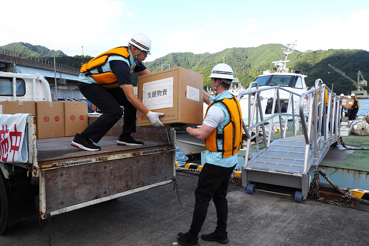 港湾業務艇「こはく」から物資をトラックに運び込む関係者