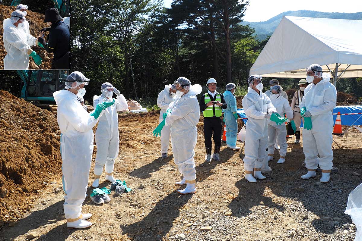 防護服の着脱訓練をする参加者。すき間がないようしっかり