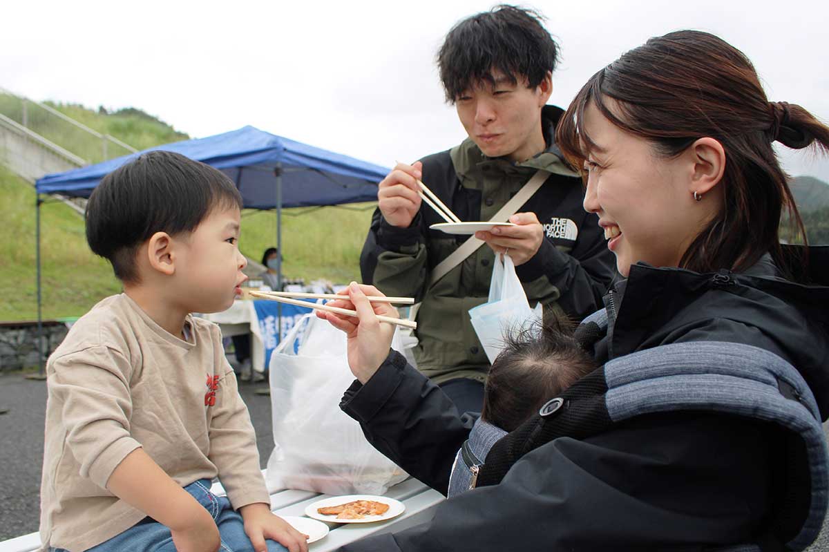 初めて食べるはまゆりサクラマスに笑顔を見せる親子