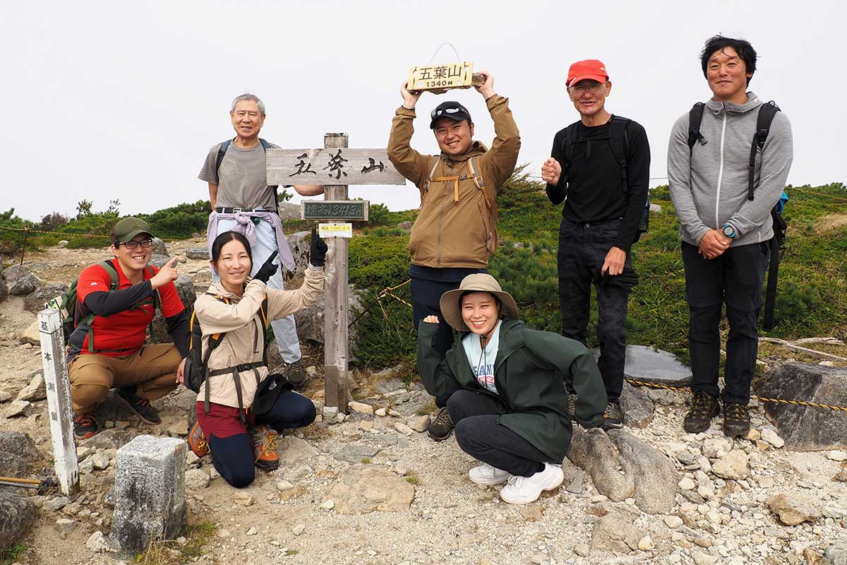 「五葉山」と記された看板を囲んで記念写真