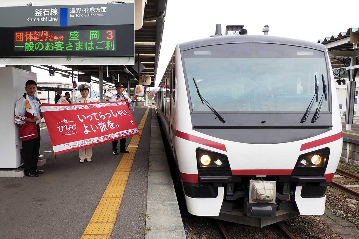 横断幕を掲げ、ひなび「秋は短し旅せよ岩手号」を見送る関係者